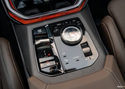 2025 BMW X3 30 interior detail of center console iDrive 9 multimedia controls and drive selector