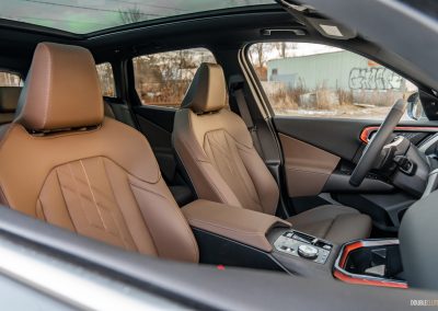 2025 BMW X3 30 interior view of front seats in brown leather through passenger window
