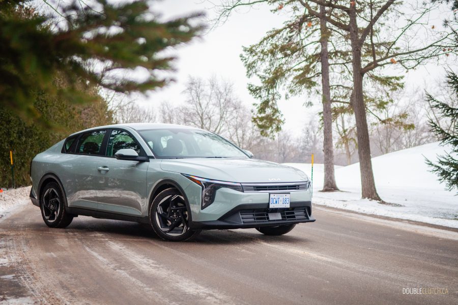 2025 Kia K4 front three quarter view against backdrop of trees