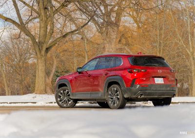Rear quarter view of a 2025 Mazda CX-50 Hybrid in the snow