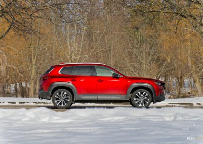 Side profile view of a 2025 Mazda CX-50 Hybrid in the snow