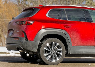 Rear quarter view of a 2025 Mazda CX-50 Hybrid in the snow