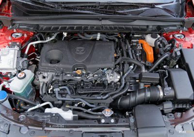 Under-hood view showing the hybrid powertrain of the 2025 Mazda CX-50 Hybrid