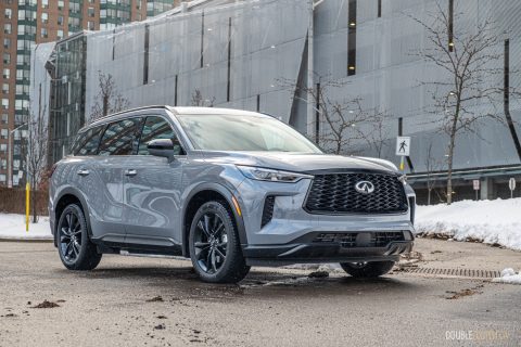 Front quarter view of a grey 2025 Infiniti QX60 in an urban parking lot