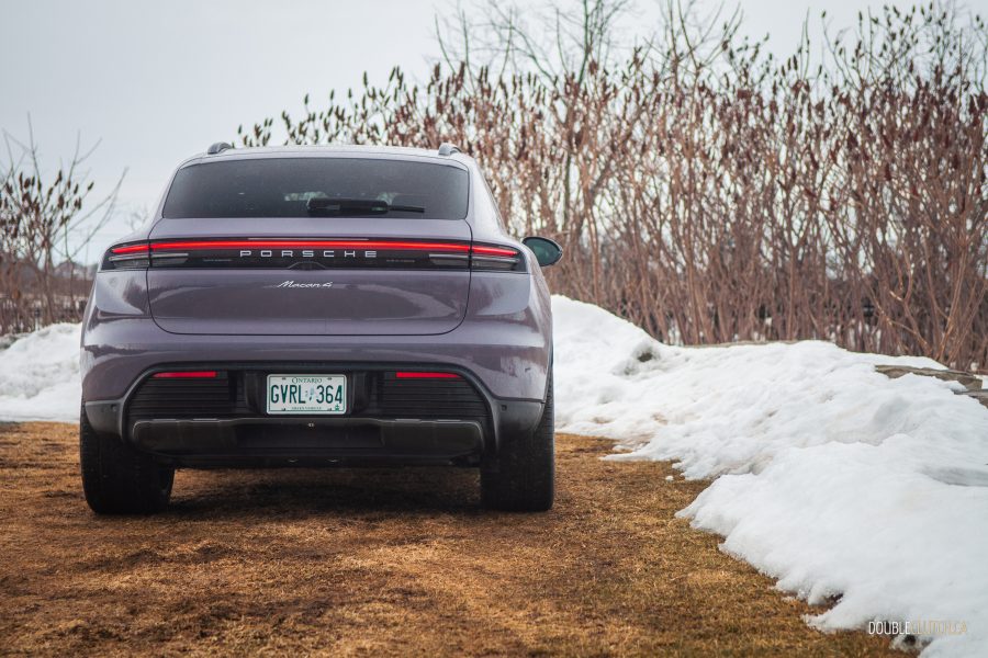 Rear view of the purple 2025 Porsche Macan Electric on a cloudy winter day