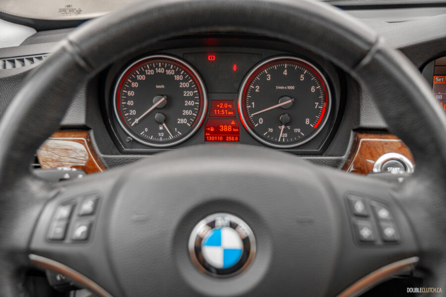 Interior close-up view of the gauge cluster and steering wheel in a 2008 BMW 335i Coupe