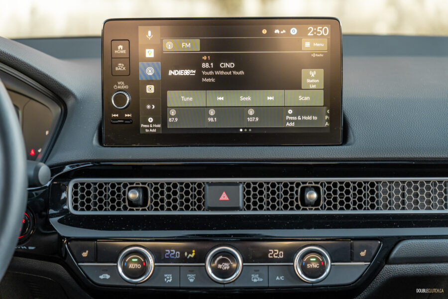 Close-up showing the infotainment display, air vent design, and climate control switchgear in a 2025 Honda Civic Hybrid Hatchback