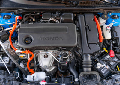 Under-hood view showing the four-cylinder engine in a 2025 Honda Civic Hybrid Hatchback