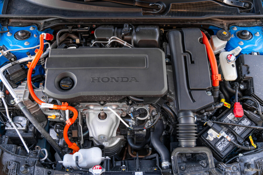 Under-hood view showing the four-cylinder engine in a 2025 Honda Civic Hybrid Hatchback