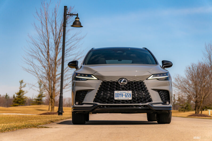 Front view of a grey 2025 Lexus RX 500h Black Line Special Edition on a sunny day with trees in the background