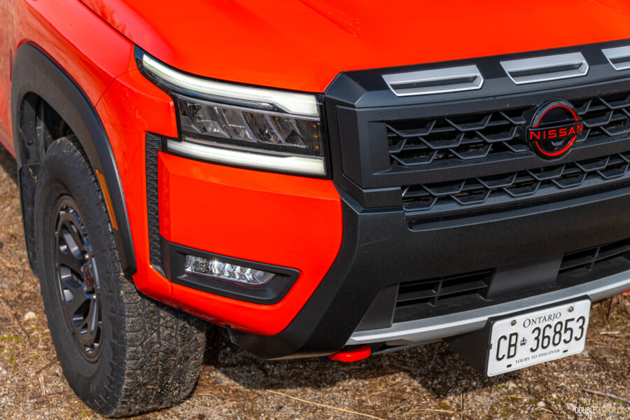 Close-up showing the restyled headlights, front grille, and bumper on a 2025 Nissan Frontier PRO-4X Luxury