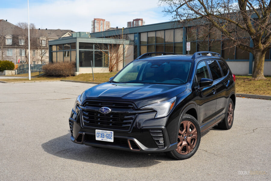 Front quarter view of a black 2025 Subaru Ascent on a sunny day, with houses in the background
