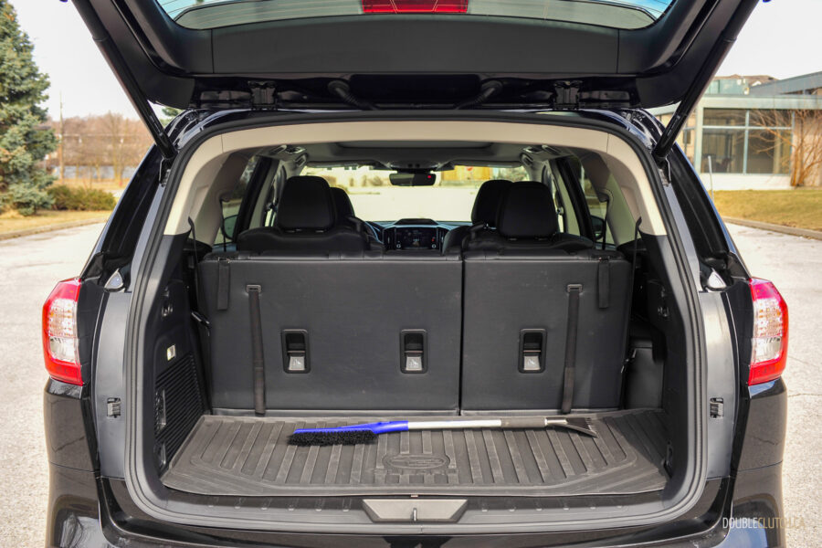 Interior view showing the cargo area with the seats up and a snow brush for scale in a 2025 Subaru Ascent