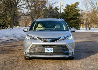 Front view of a 2025 Toyota Sienna against a backdrop of trees