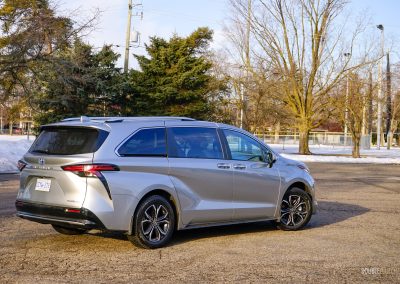 Rear quarter view of a 2025 Toyota Sienna against a backdrop of trees