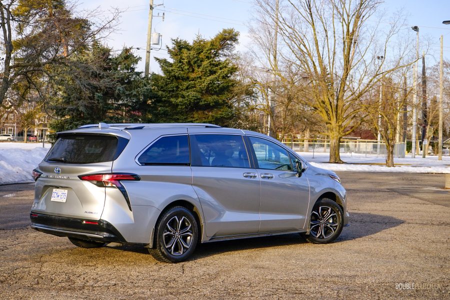 Rear quarter view of a 2025 Toyota Sienna against a backdrop of trees