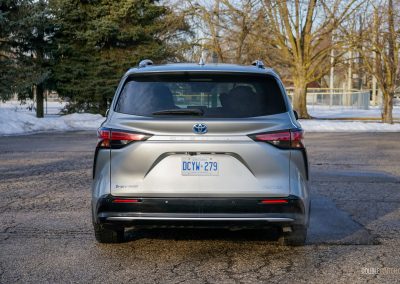 Rear view of a 2025 Toyota Sienna against a backdrop of trees