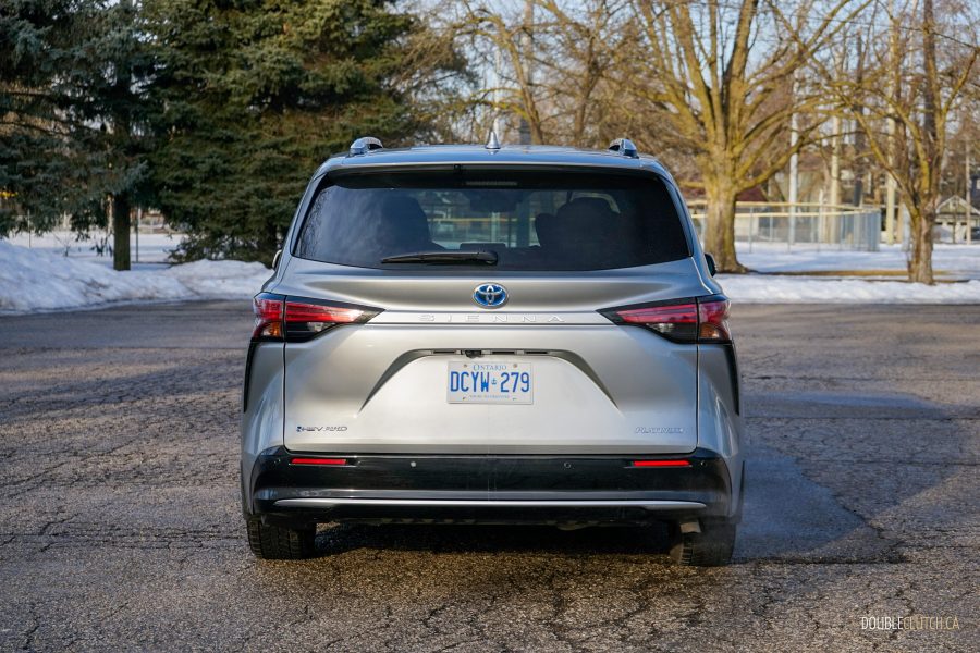 Rear view of a 2025 Toyota Sienna against a backdrop of trees