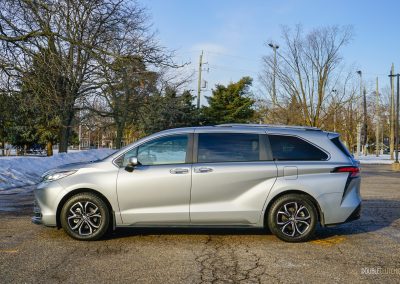 Side profile view of a 2025 Toyota Sienna against a backdrop of trees