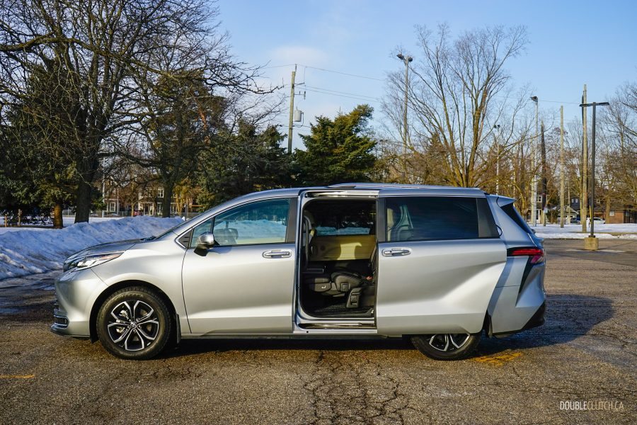 Side profile view of a 2025 Toyota Sienna with the door open against a backdrop of trees