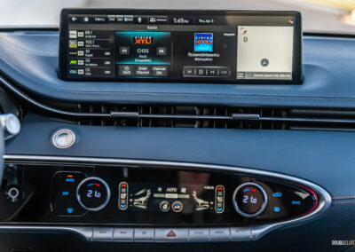Close-up of the infotainment display and climate controls in a 2025 Genesis GV70 3.5T Sport Plus