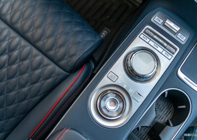 Close-up showing the infotainment knob and shifter dial arrangement in a 2025 Genesis GV70 3.5T Sport Plus