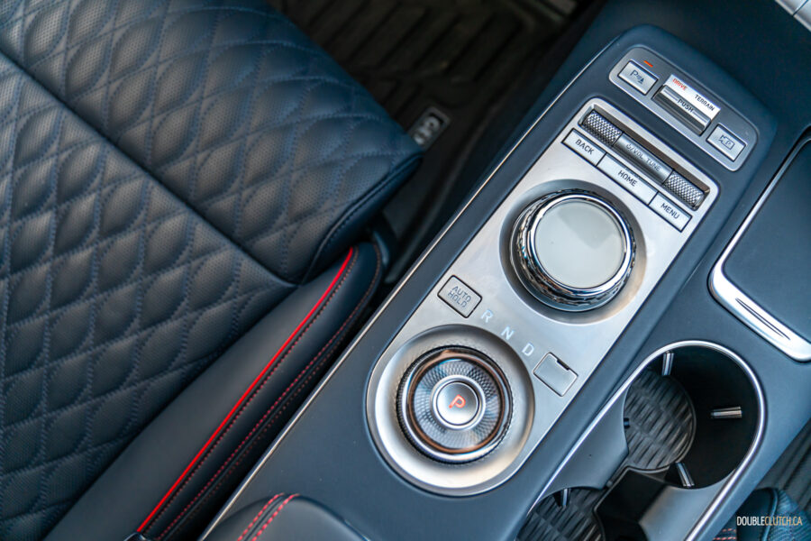 Close-up showing the infotainment knob and shifter dial arrangement in a 2025 Genesis GV70 3.5T Sport Plus
