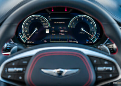 Close-up showing the digital gauge cluster and steering wheel in a 2025 Genesis GV70 3.5T Sport Plus
