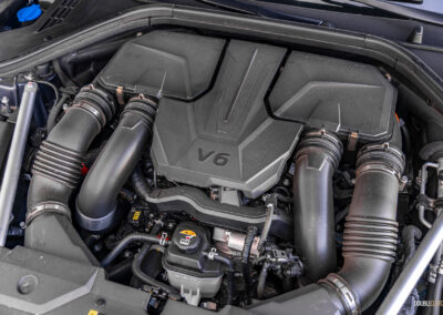 Under-hood view showing the twin-turbocharged V6 in a 2025 Genesis GV70 3.5T Sport Plus