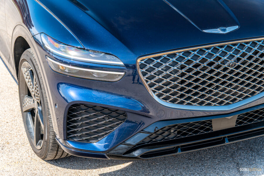 Close-up showing the headlight, grille, and front fascia design on a 2025 Genesis GV70 3.5T Sport Plus