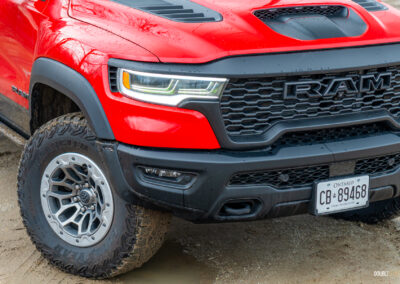 Cropped front quarter view of a red 2025 Ram 1500 RHO, showing the restyled front fascia and wheels