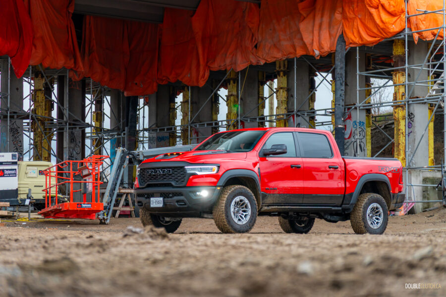 Front quarter view of a red 2025 Ram 1500 RHO, parked in a muddy construction site