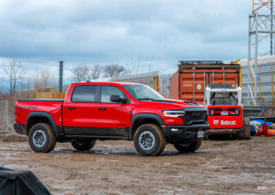 Front quarter view of a red 2025 Ram 1500 RHO, parked in a muddy construction site