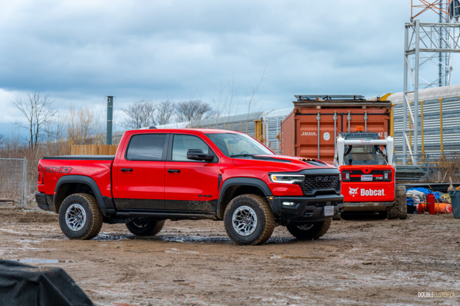 Front quarter view of a red 2025 Ram 1500 RHO, parked in a muddy construction site