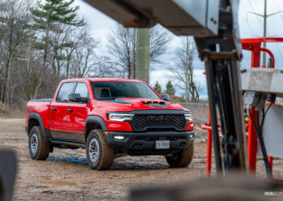 Front quarter view of a red 2025 Ram 1500 RHO, parked in a muddy construction site