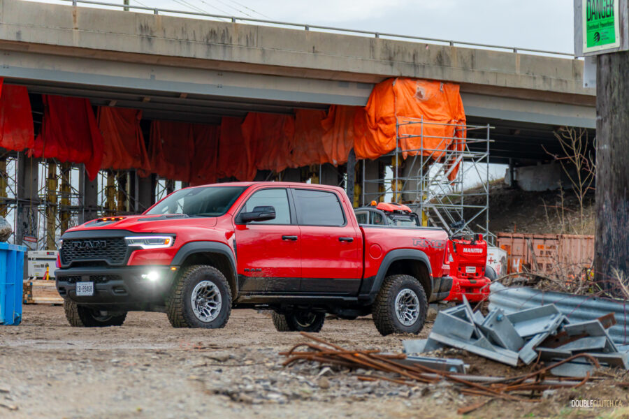 Front quarter view of a red 2025 Ram 1500 RHO, parked in a muddy construction site