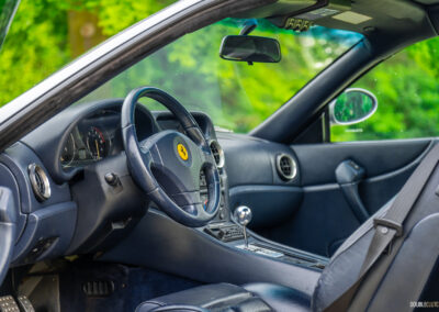 The blue interior of a 1996 Ferrari 550 Maranello, from the outside looking in at the cockpit