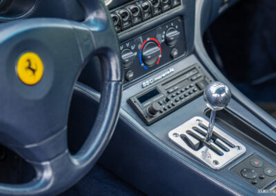Close-up of the steering wheel and gated shift mechanism in a 1996 Ferrari 550 Maranello