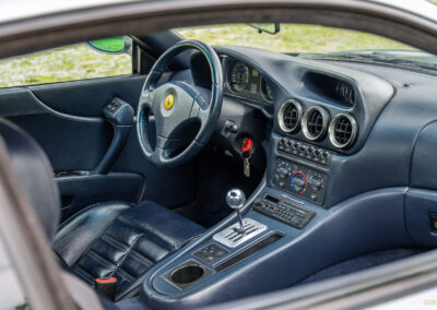 The blue interior of a 1996 Ferrari 550 Maranello, from the outside looking in at the cockpit through the driver's side door