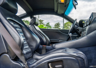 The blue interior of a 1996 Ferrari 550 Maranello, from the outside looking in at the front passenger seat