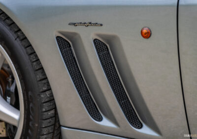 Close-up of the stylized fender vents on a grey 1996 Ferrari 550 Maranello