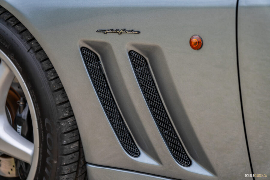 Close-up of the stylized fender vents on a grey 1996 Ferrari 550 Maranello
