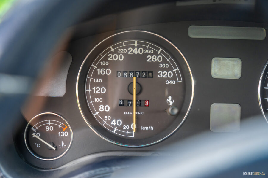 Close-up of the speedometer and engine temperature gauge in a 1996 Ferrari 550 Maranello