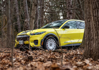 Front quarter view of a yellow 2025 Ford Mustang Mach-E Rally in a forest