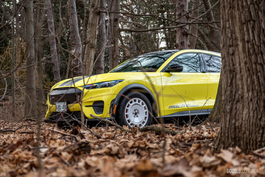 Front quarter view of a yellow 2025 Ford Mustang Mach-E Rally in a forest