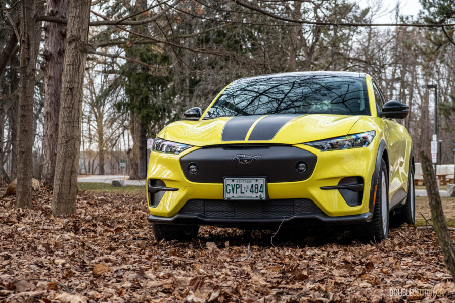 Front view of a yellow 2025 Ford Mustang Mach-E Rally in a forest