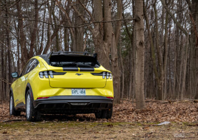 Front quarter view of a yellow 2025 Ford Mustang Mach-E Rally in a forest