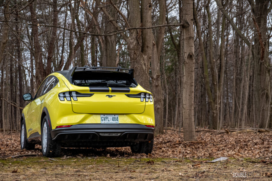Front quarter view of a yellow 2025 Ford Mustang Mach-E Rally in a forest