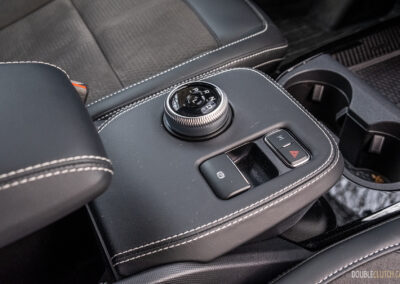 Close-up showing the shifter dial, centre console, and armrest in a 2025 Ford Mustang Mach-E Rally