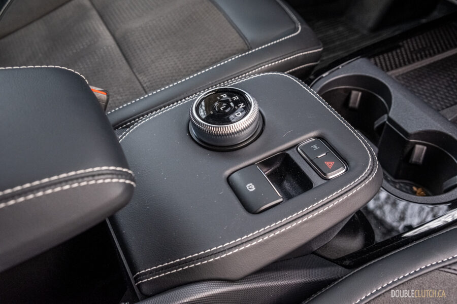 Close-up showing the shifter dial, centre console, and armrest in a 2025 Ford Mustang Mach-E Rally